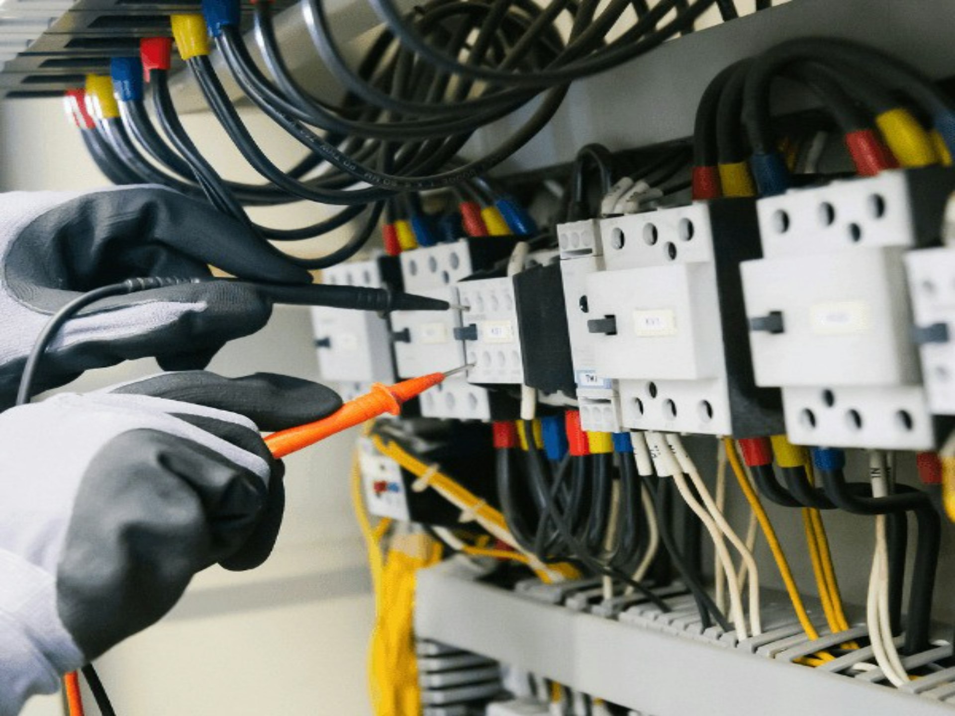 Električar proverava razvodni ormar mernim instrumentom